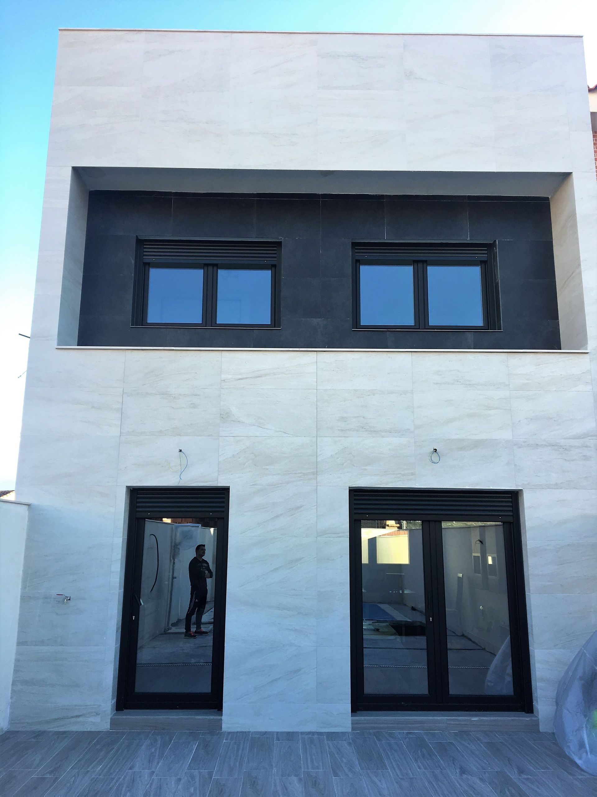 Un edificio blanco con ventanas y puertas negras.