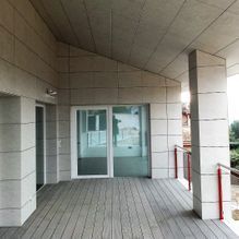 Un gran porche cubierto con una puerta corrediza de vidrio que conduce a una habitación.