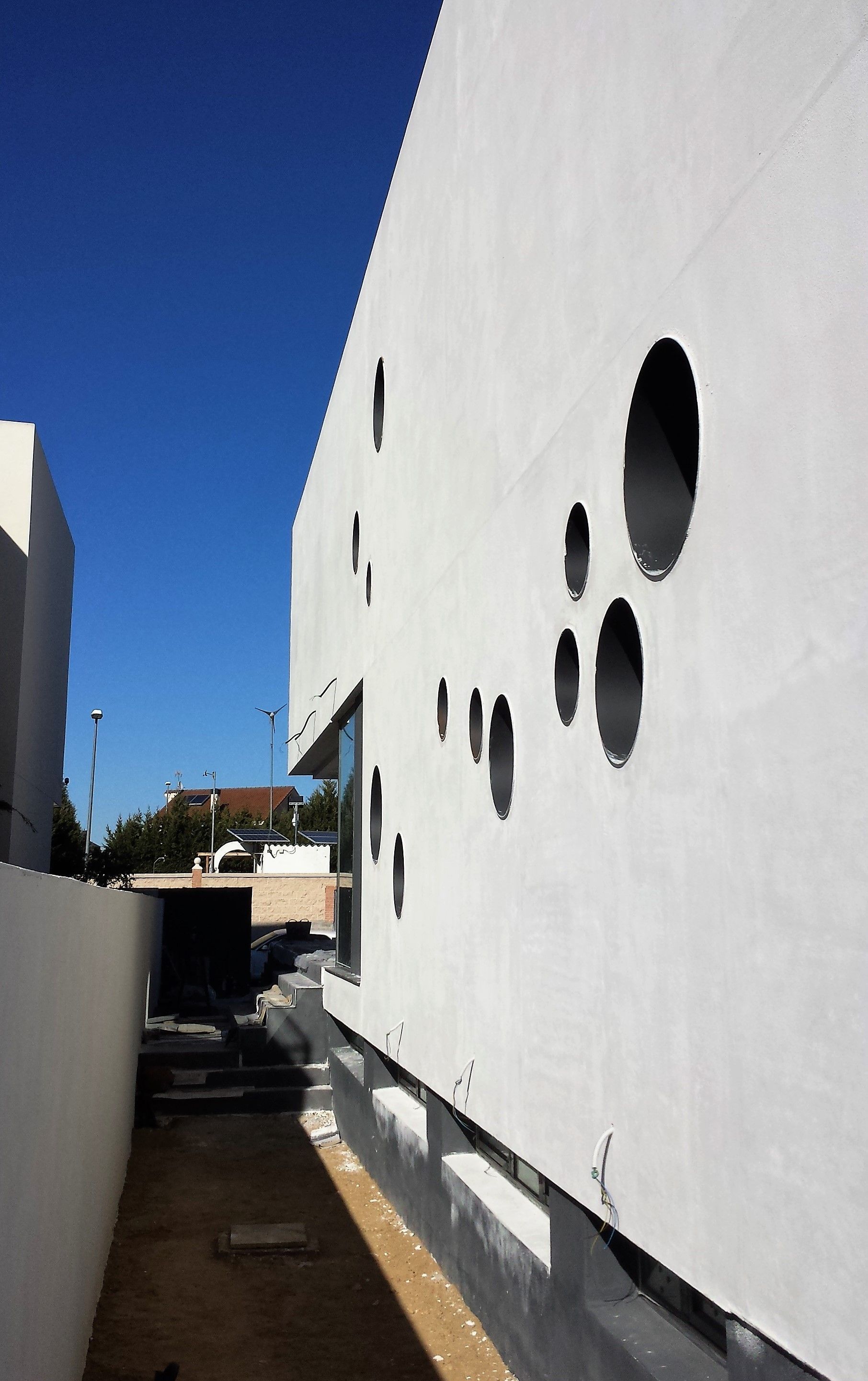 Un edificio blanco con agujeros y un cielo azul al fondo.