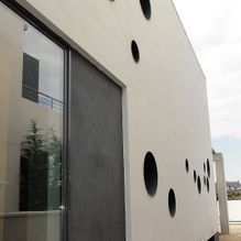 Un edificio blanco con una puerta negra y muchas ventanas.