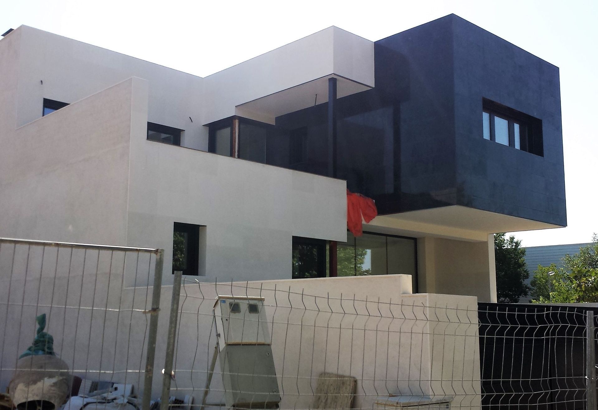 Un gran edificio blanco y negro con una valla delante.