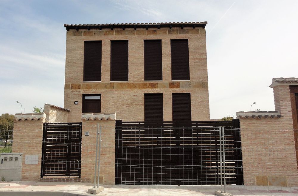 Un gran edificio de ladrillo con una puerta negra delante.
