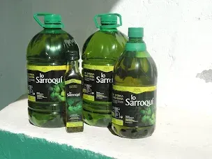 Tres grandes jarras de plástico verde y una pequeña botella de vidrio de aceite de oliva Lo Sarroqui