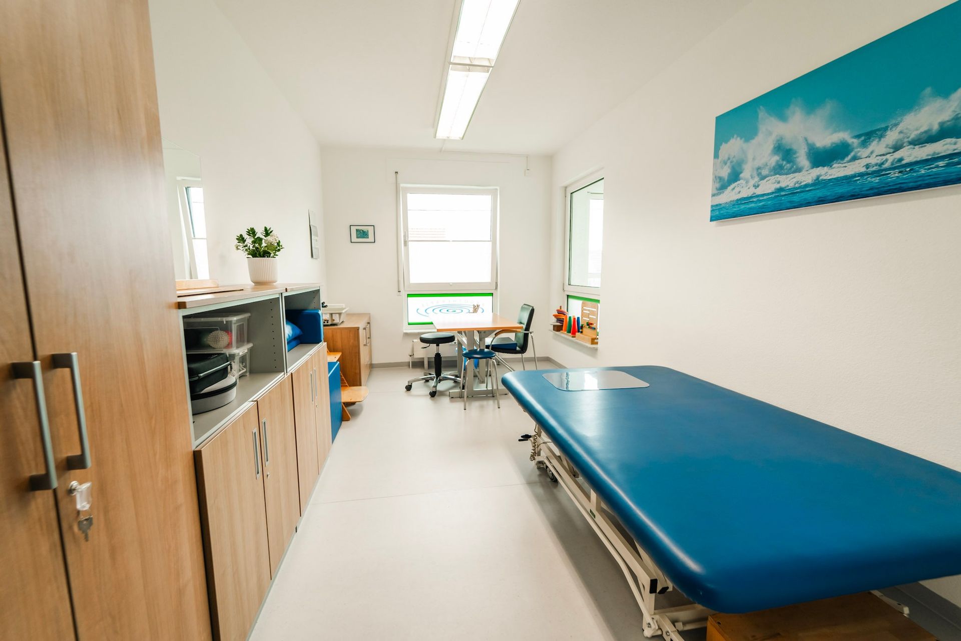 Helles Zimmer mit blauer Liege und Schrank