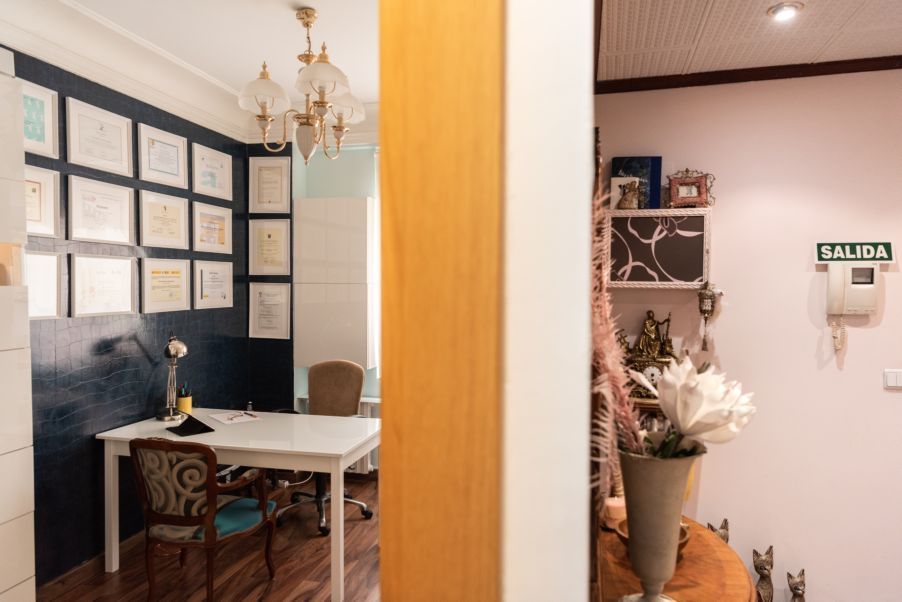 Una habitación con una mesa y sillas y un jarrón con flores sobre la mesa.