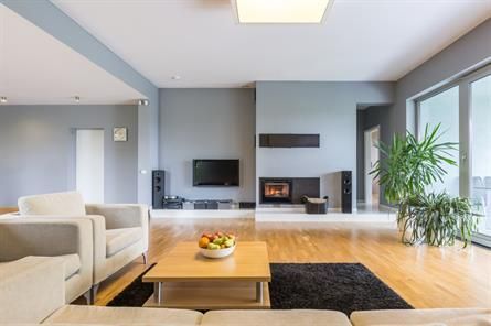 Ein Wohnzimmer mit Couch, Stühlen, Couchtisch und Fernseher.