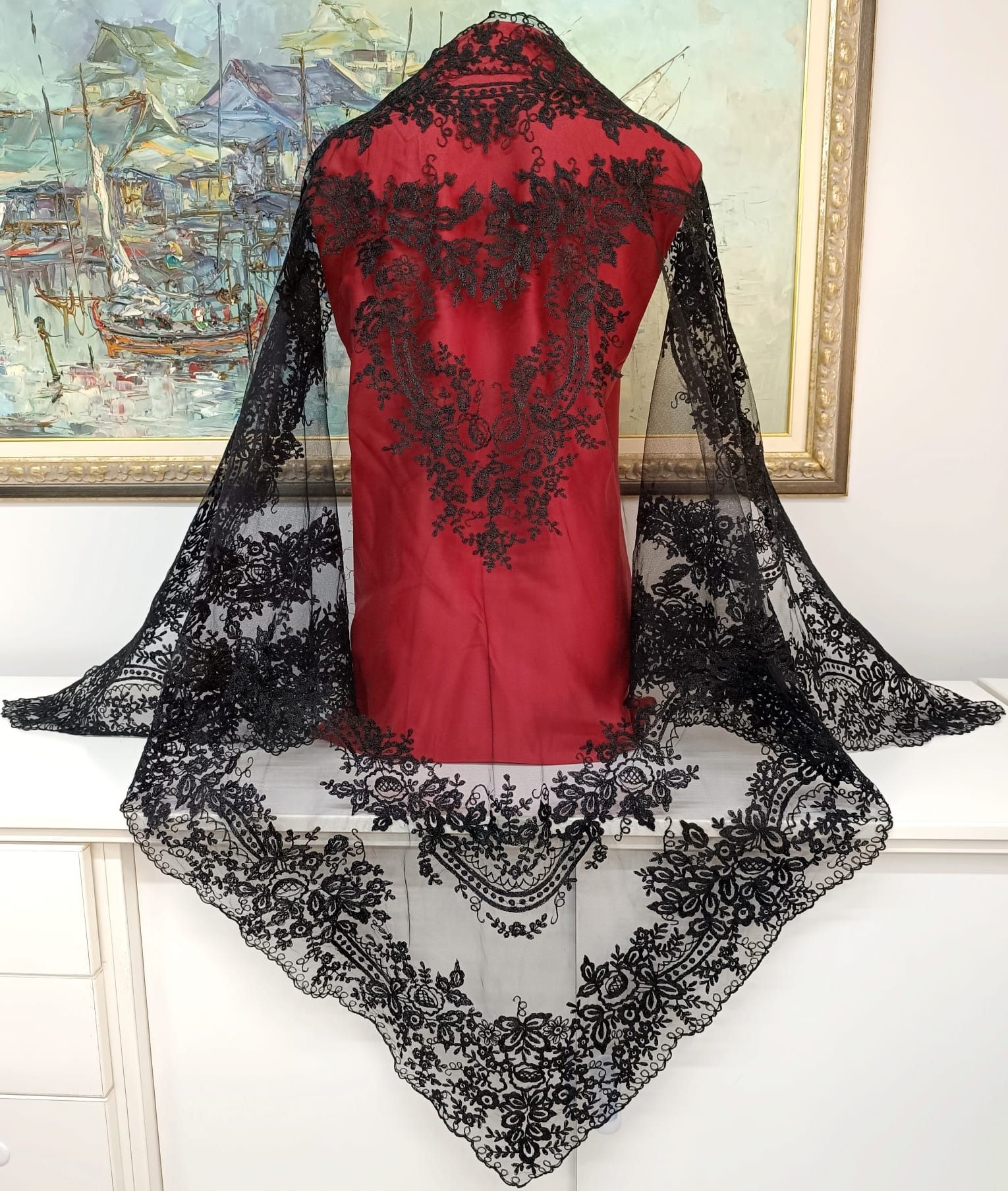 Un maniquí con una camisa roja y una bufanda de encaje negra.