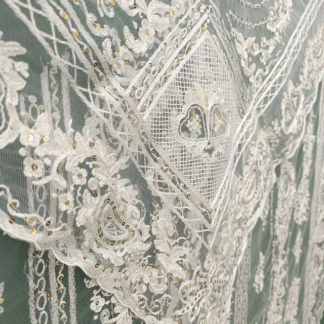 Un primer plano de una tela de encaje blanco sobre un fondo verde.