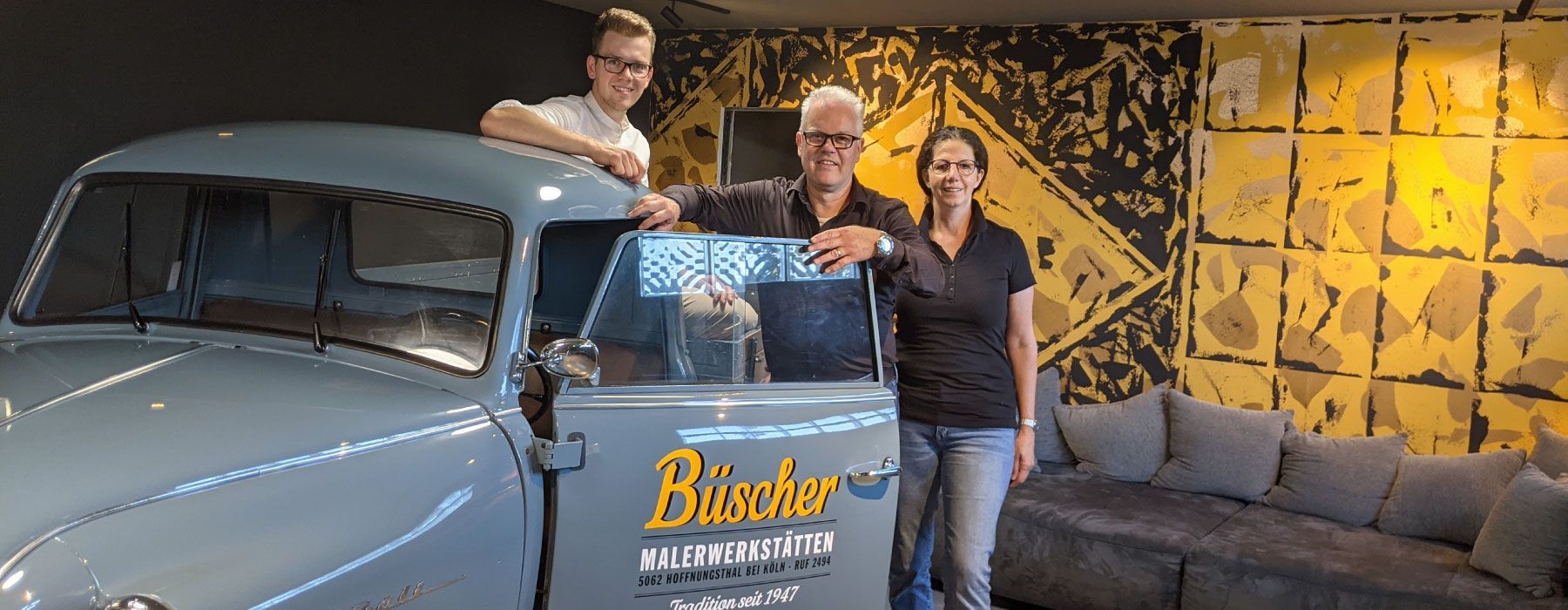 Drei Leute stehen vor einem Auto mit der Aufschrift „Busser“