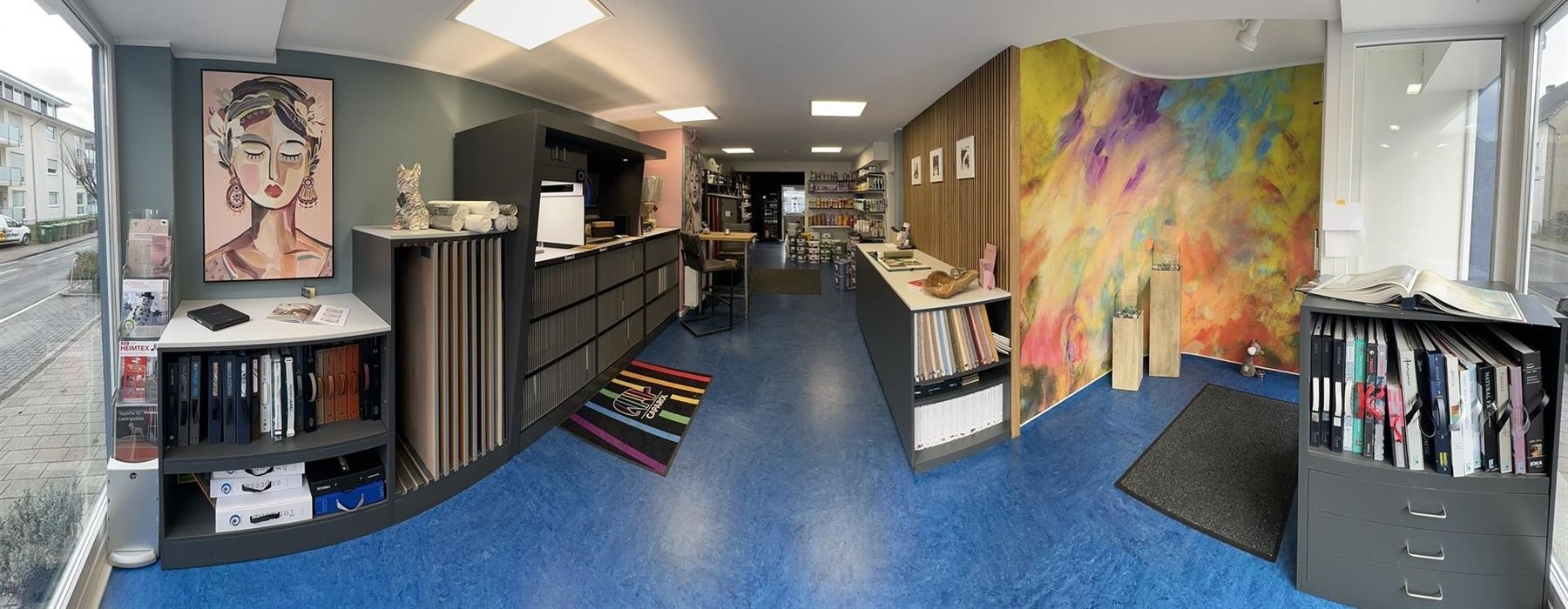 Ein Raum mit blauem Boden und einem Gemälde an der Wand