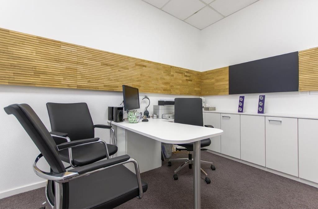 Ein kleines Büro mit Schreibtisch und Stühlen