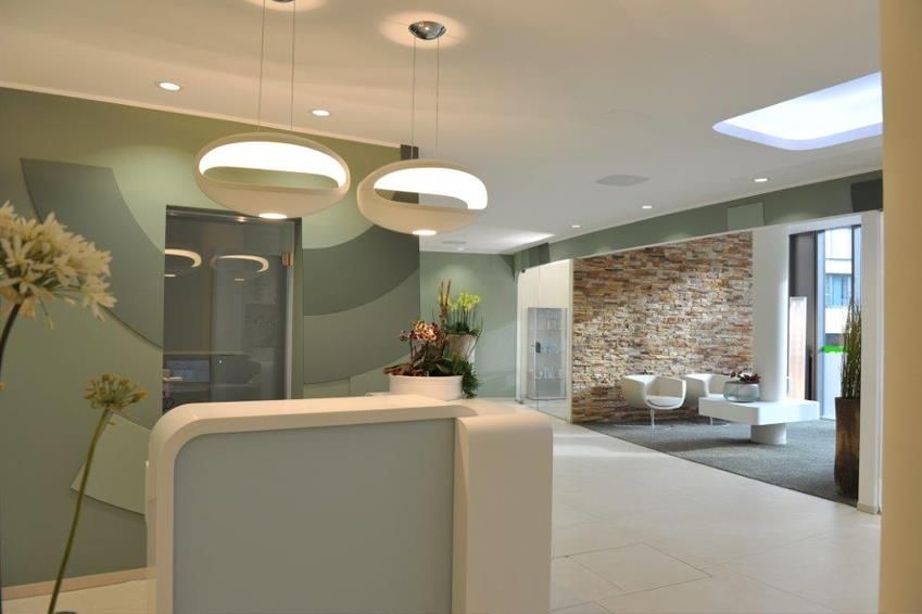 Ein Empfangsbereich mit einem weißen Tresen und einer Backsteinwand