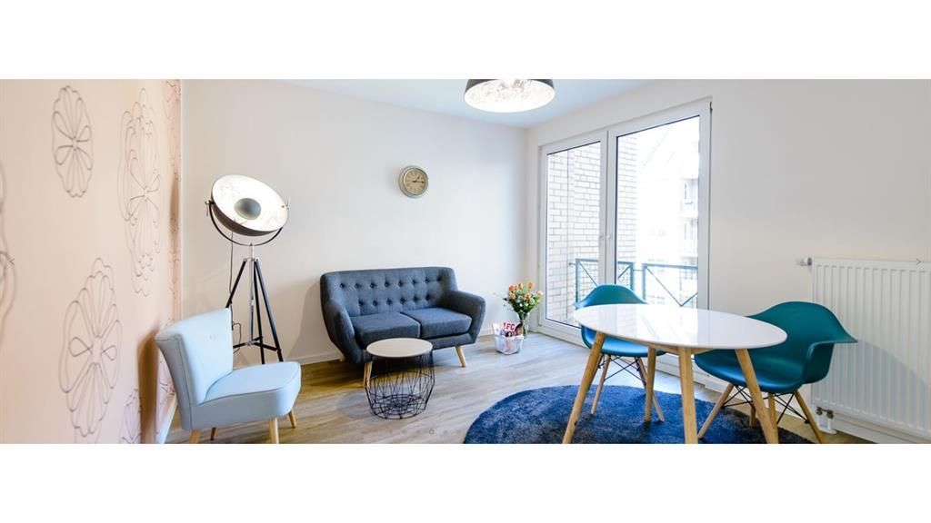 Ein Wohnzimmer mit einer Couch, Stühlen, einem Tisch und einer Lampe.