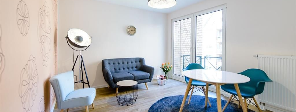 Ein Wohnzimmer mit einer Couch, Stühlen, einem Tisch und einer Lampe.