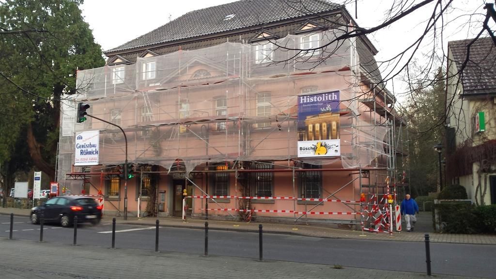 Ein Gebäude mit Gerüsten darum und einem Schild mit der Aufschrift 