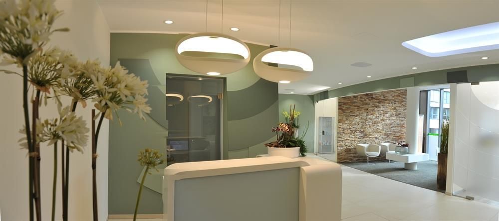 Ein Empfangsbereich mit weißem Tresen und Blumen an der Wand