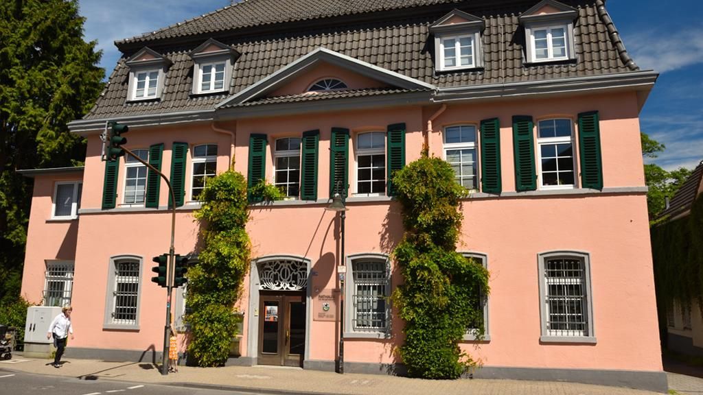 Ein großes rosa Gebäude mit grünen Fensterläden