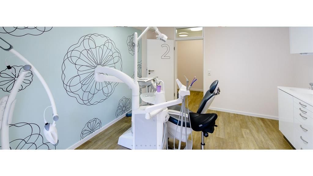 Eine Zahnarztpraxis mit einer blauen Wand und einem Stuhl