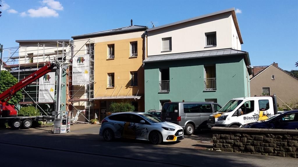 Mehrere Autos sind vor einem im Bau befindlichen Gebäude geparkt