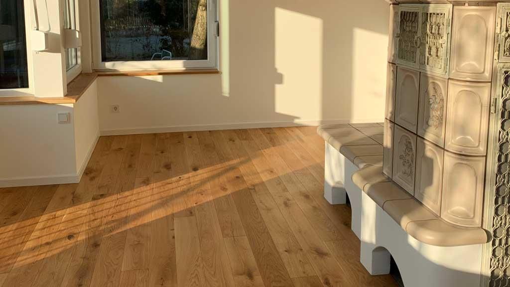 Ein Wohnzimmer mit Holzboden und Fenster.