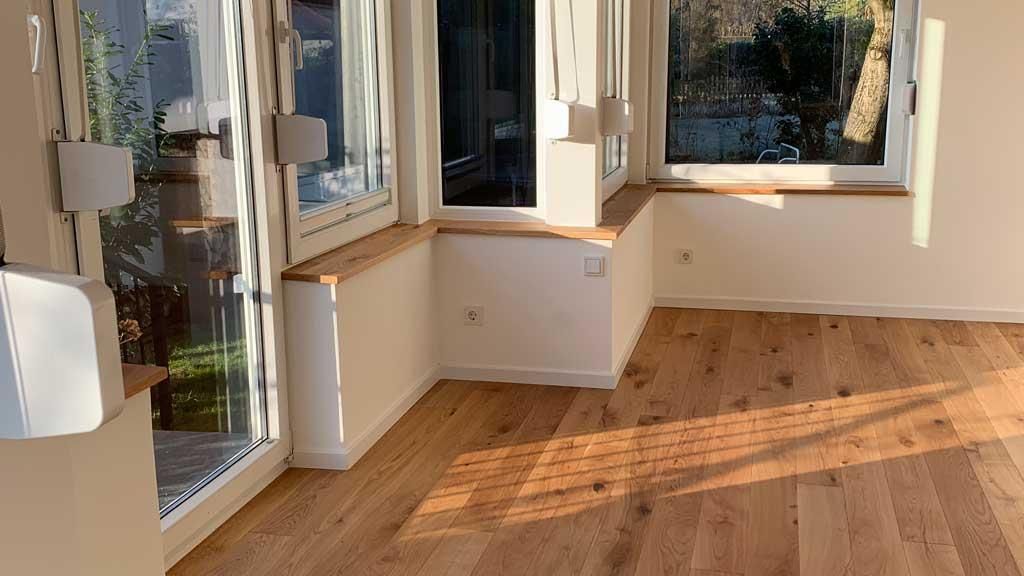 Ein leerer Raum mit Holzboden und Fenster.