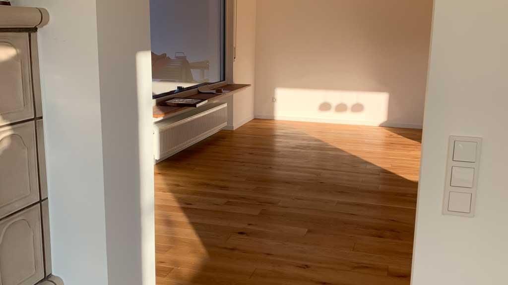 Ein leerer Raum mit Holzboden und Fenster.