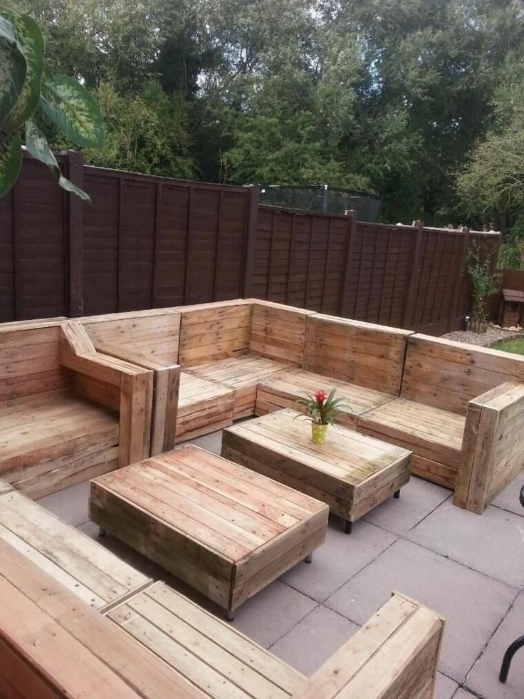 Un patio de madera con un sofá y una mesa hechos con palets de madera.