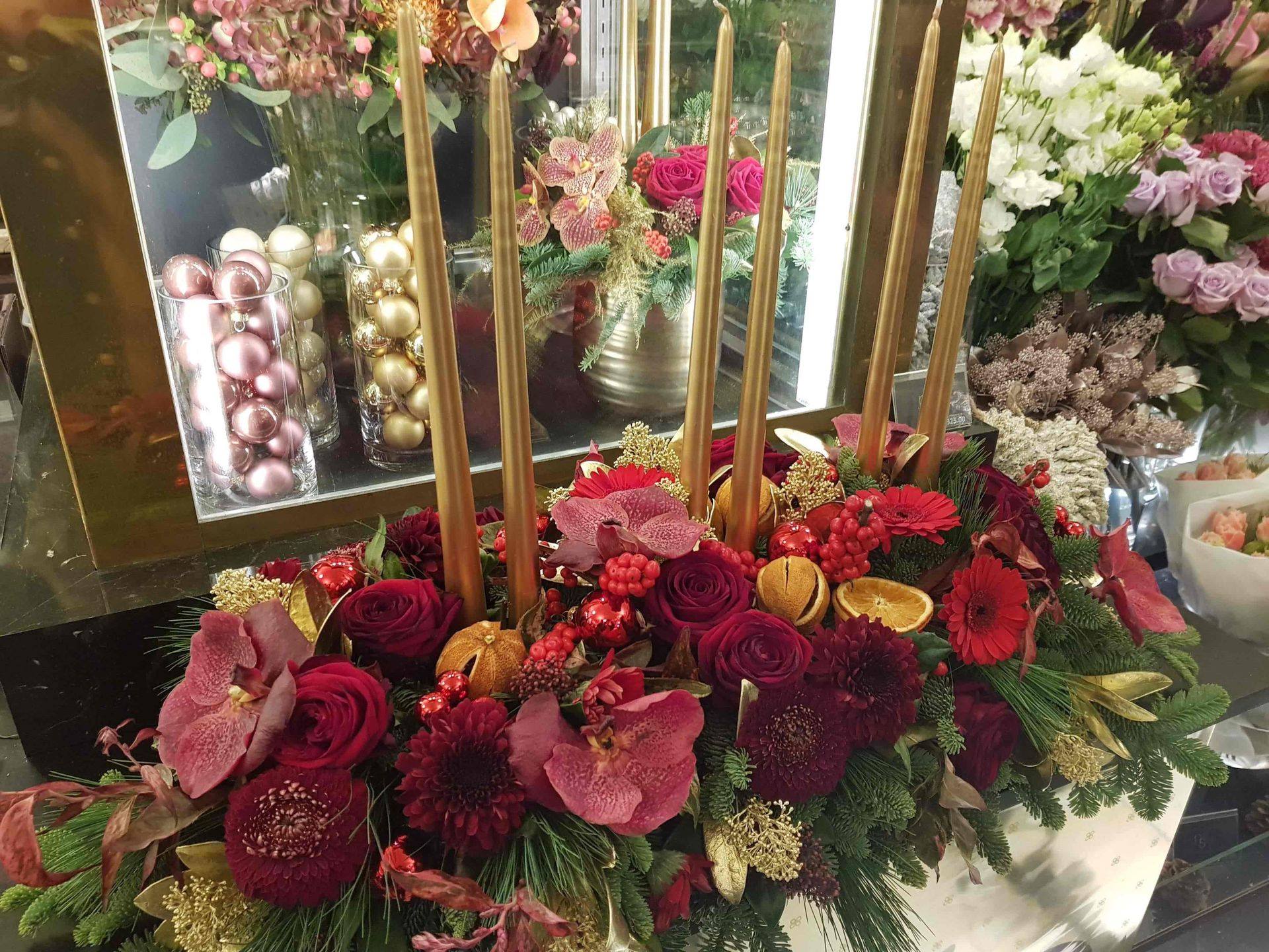 Fleurs rouges habillant des bougies dorées