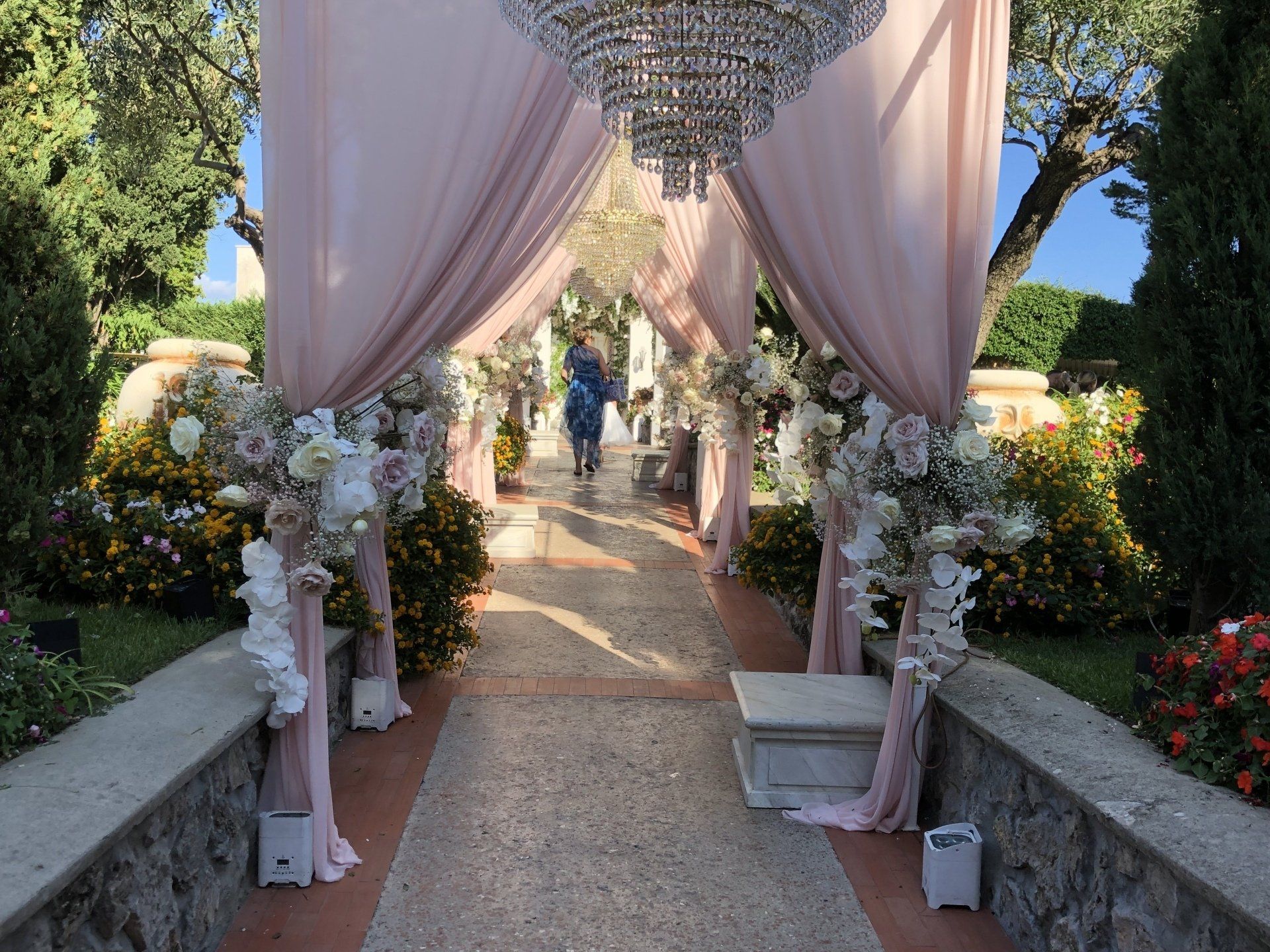Couple marié dans une allée décorée de fleurs