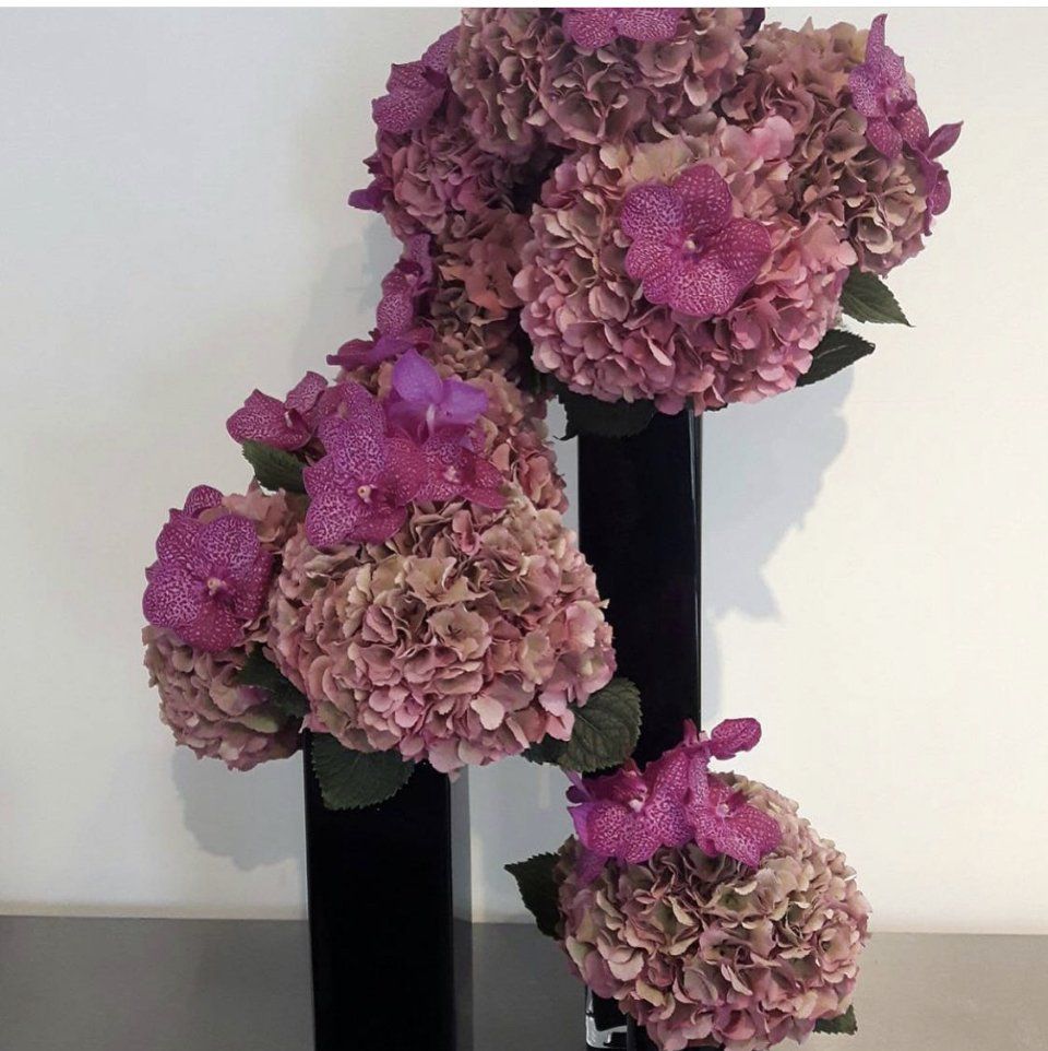 Trois bouquets roses dans trois vases noirs