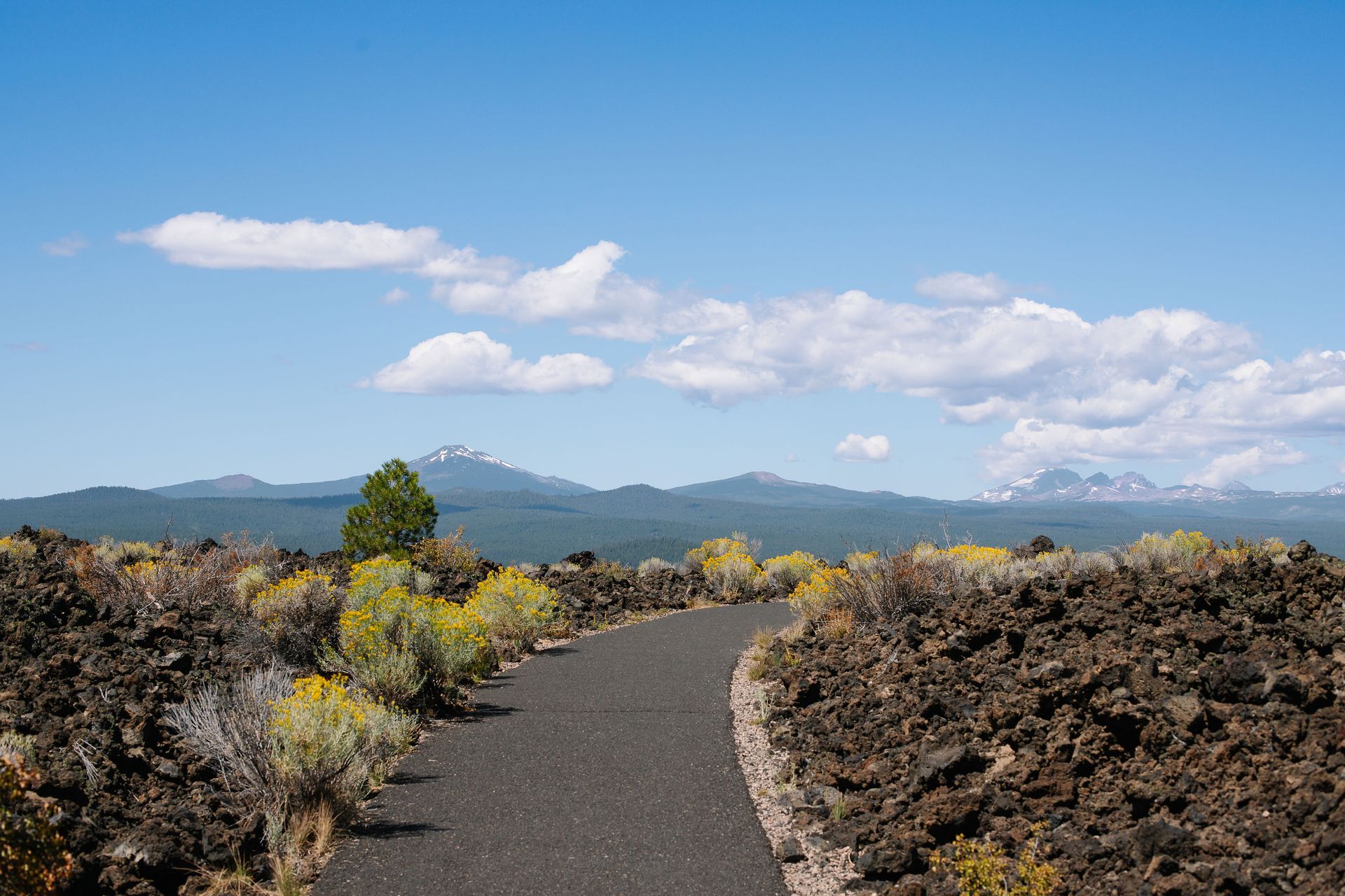view of the Cascade Mountains from a trail through lava rock to represent the best Central Oregon hiking trails