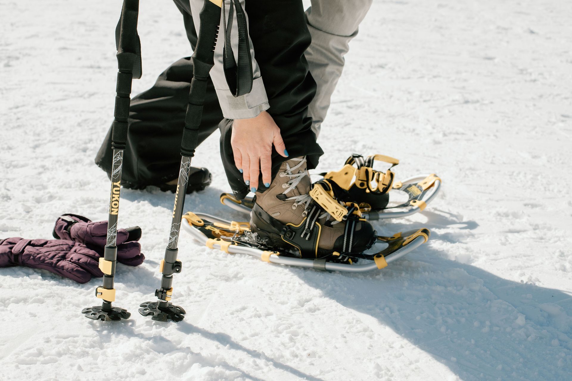 snowshoer putting on snowshoes to represent the top dog friendly snowshoe trails in Central Oregon