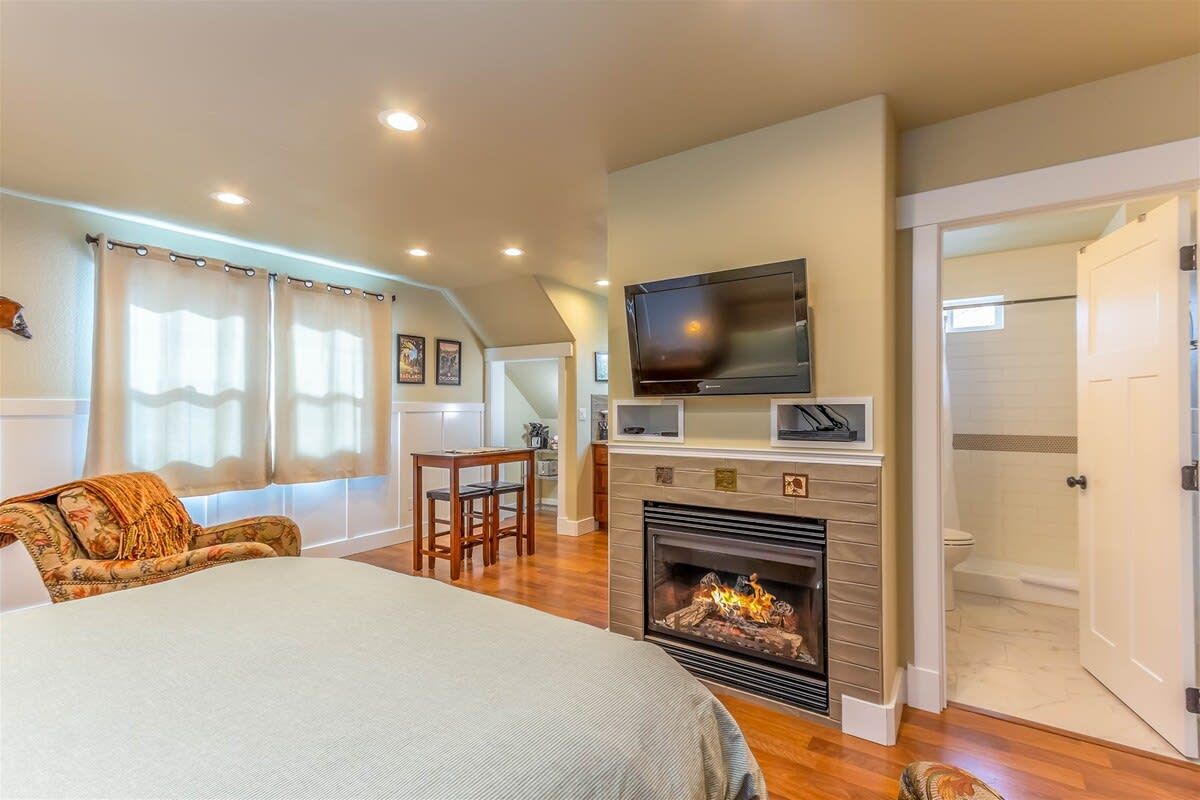 Cumberland Bungalow a studio vacation rental in Bend with fireplace, bathroom, bed, and table in view
