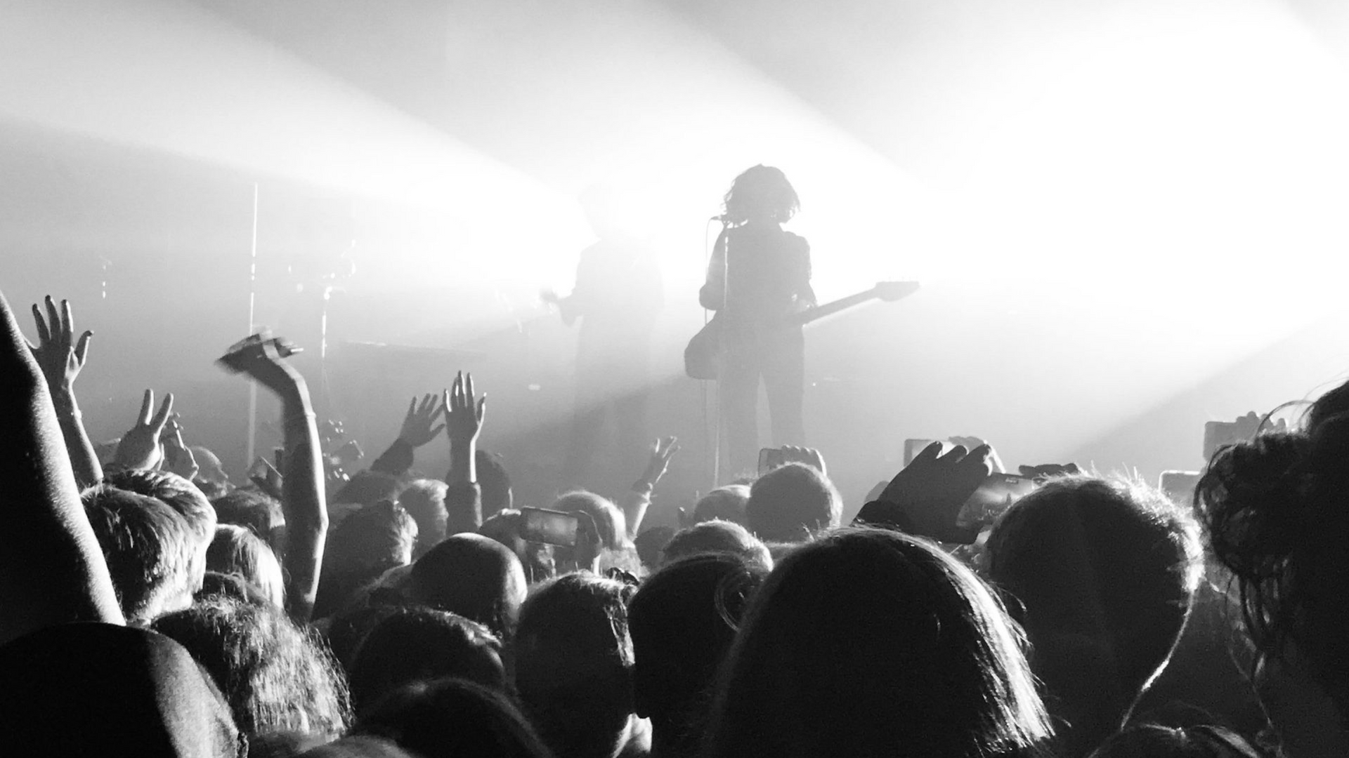 person taking a picture of the stage during a concert at Hayden Homes Amphitheater in Bend