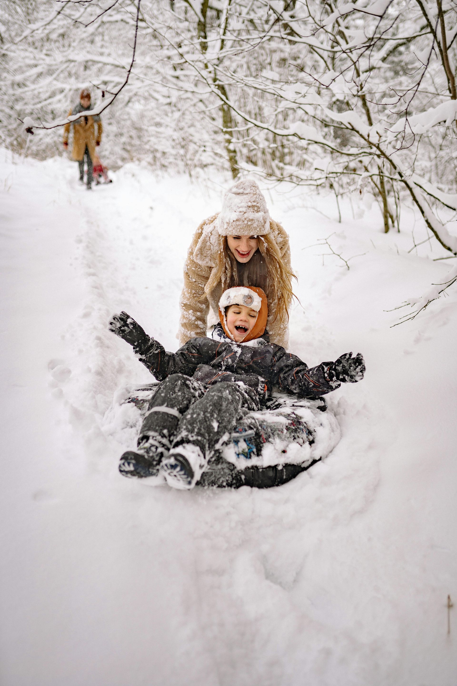 People sledding in a snowy location to represent a winter packing list for Central Oregon