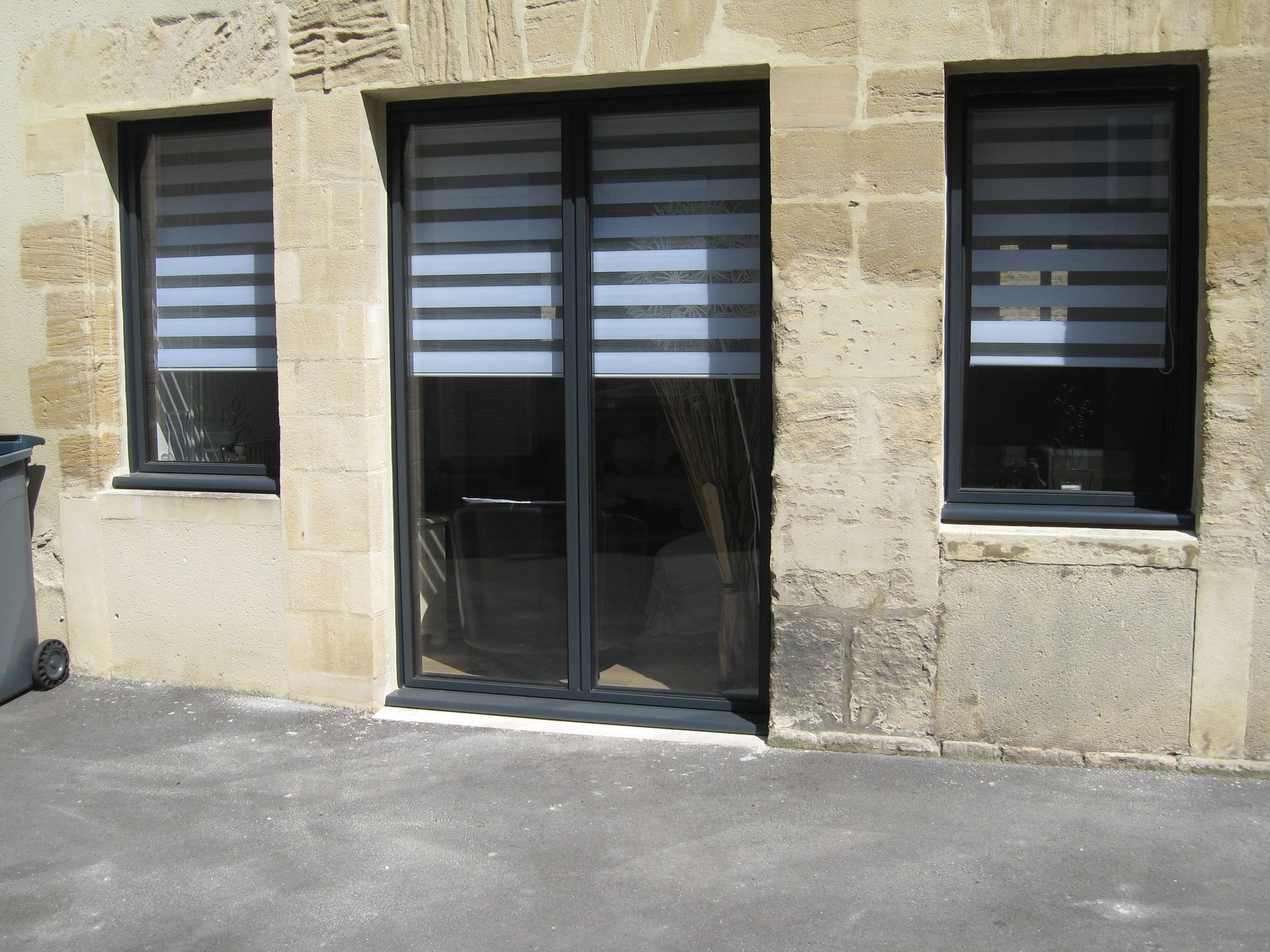 Baie vitrée entre deux fenêtres.