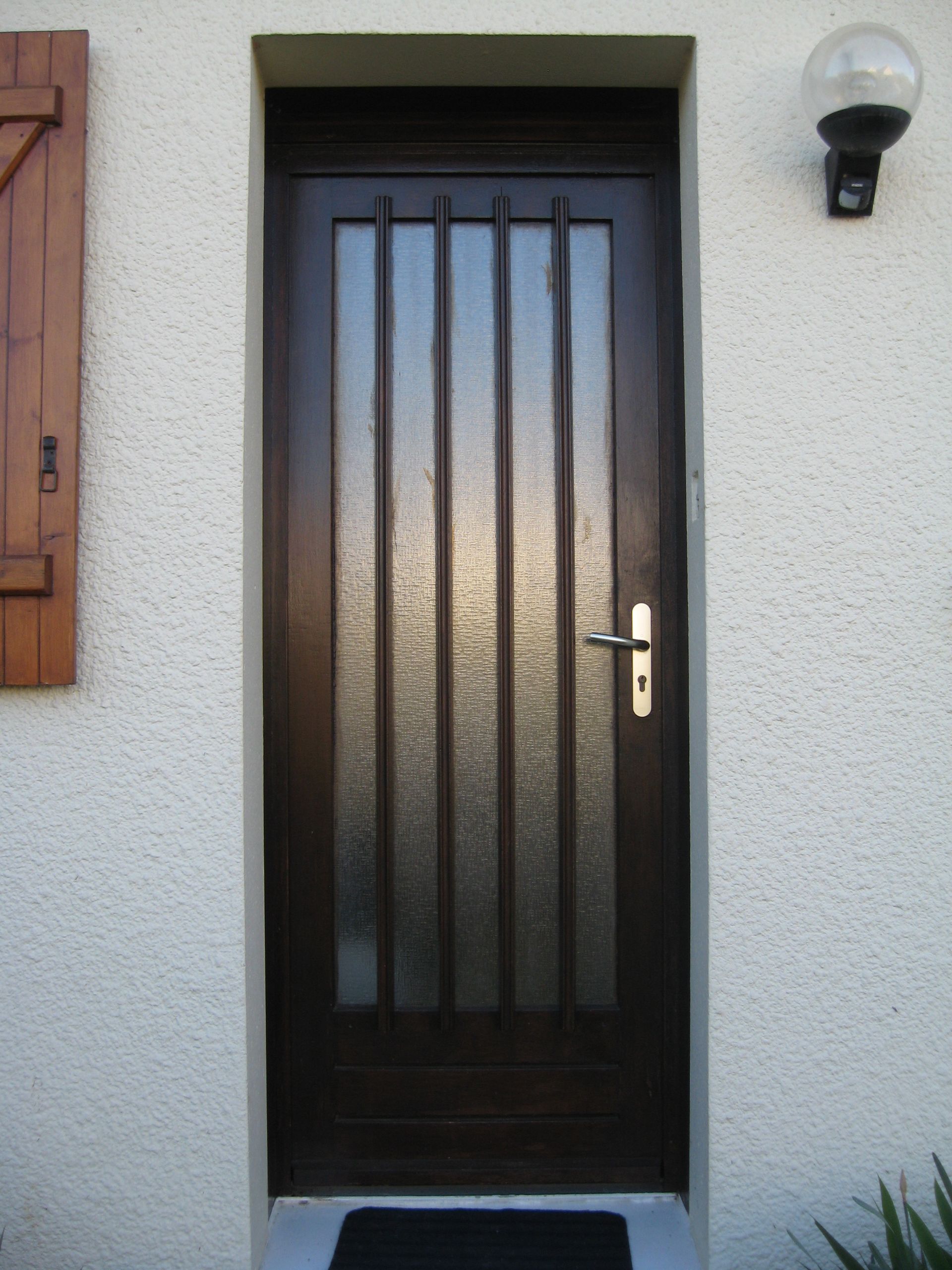 Porte d'entrée en bois foncé.