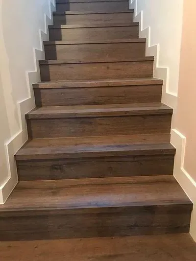 Un conjunto de escaleras de madera que conducen al segundo piso de una casa.