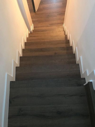 Un conjunto de escaleras de madera que conducen al segundo piso de una casa.