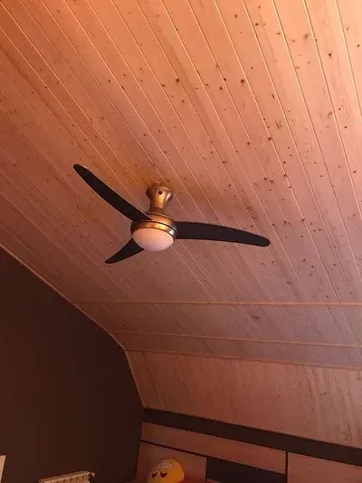 Un ventilador de techo cuelga del techo de un dormitorio.