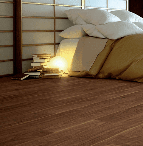 Un dormitorio con una cama y una pila de libros en el suelo.