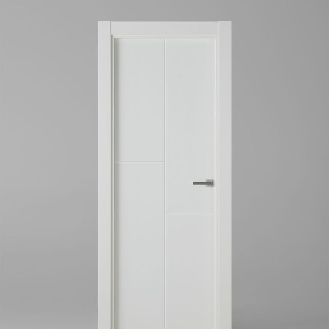 Una puerta blanca con manija negra está contra una pared gris.