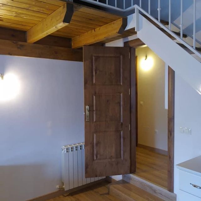 Una habitación con una escalera y una puerta abierta.