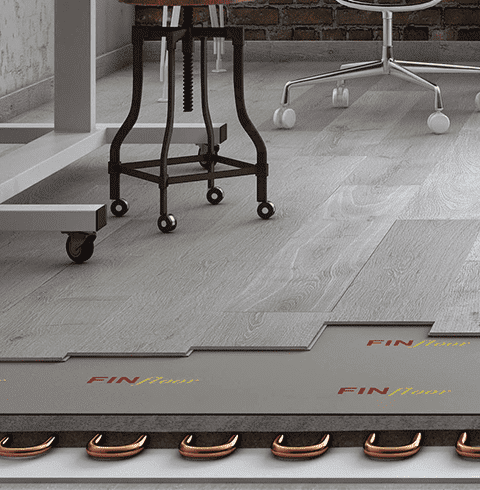 Un taburete está sobre un piso de madera al lado de un escritorio y una silla.