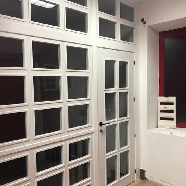 Una habitación con una ventana roja y puertas blancas