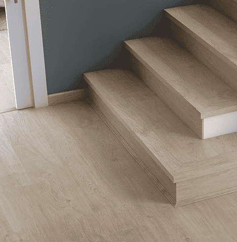 Un primer plano de una escalera de madera con piso de madera.