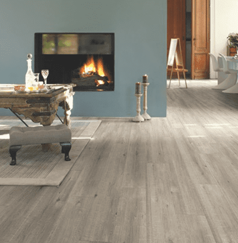 Una sala de estar con chimenea y suelo de madera.