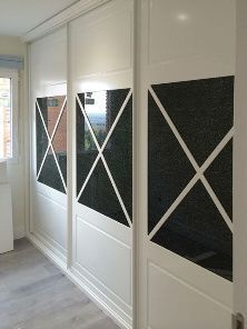 Un dormitorio con puertas corredizas de vidrio y una ventana.