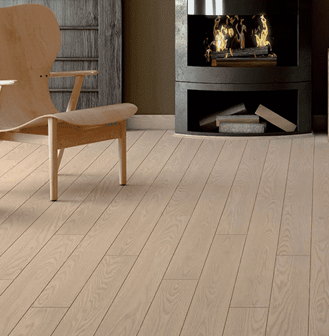 Una silla de madera está junto a una chimenea en una sala de estar.