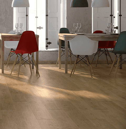 Un comedor con mesa y sillas y suelo de madera.